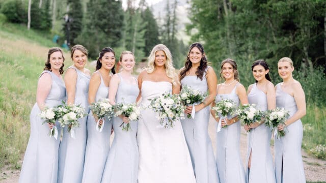 Bridesmaids holding white roses and wedding flowers near me for a Vail mountain wedding.